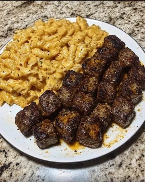 Spicy Garlic Butter Steak with Cheddar Cream Rotini in a rustic skillet.