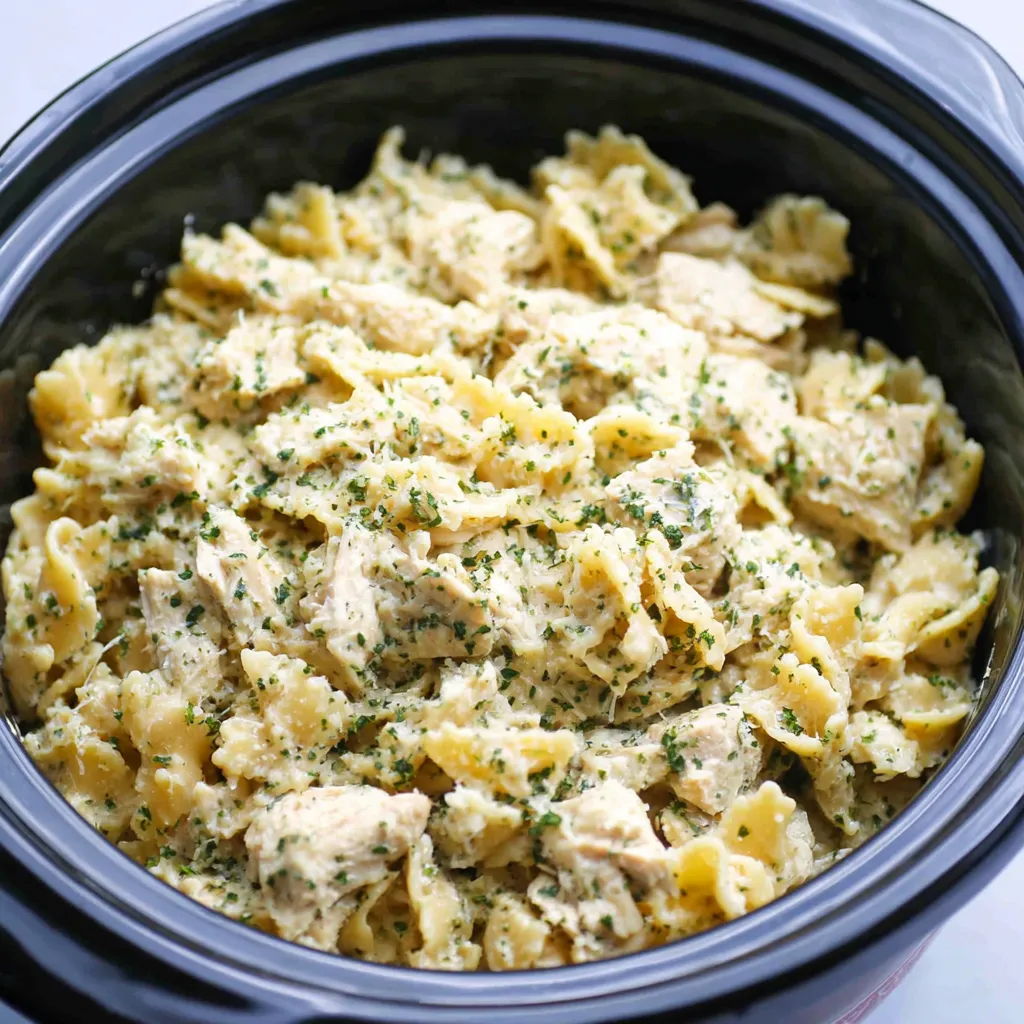 Creamy Crockpot Garlic Parmesan Chicken Pasta is shown as a delicious and easy family meal in a featured image.